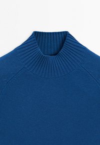 Pull en tricot bleu avec un col montant côtelé et de longues manches raglan sur fond blanc.
