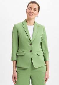 Mintgrüner taillierter Blazer mit Dreiviertelärmeln, zwei braunen Knöpfen und Fronttaschen, aus einem glatten Stoff gefertigt.