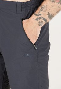 Marine CMP shorts med elastisk talje, lynlåslomme på siden og diskret logo; letvægtigt stof med glat tekstur.
