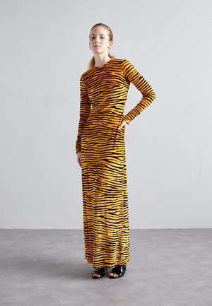 Long-sleeve maxi dress made of soft, stretchy fabric with a bold orange and black tiger stripe pattern, fitted silhouette, and side slits.