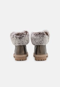 Botas de tobillo de cuero marrón con un cuello de piel sintética beige y esponjosa y suelas de goma duraderas. Presentan un acabado texturizado y detalles de costura.