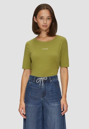 T-shirt vert olive à manches courtes, avec un col rond et le logo blanc "S. OLIVER". Associé à un pantalon en denim bleu ample.
