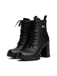 Fekete bőr bokacsizma, vastag magas sarkúval, fűzős kivitelben, húzófüllel és egy kis Tommy Jeans logóval az oldalon.
