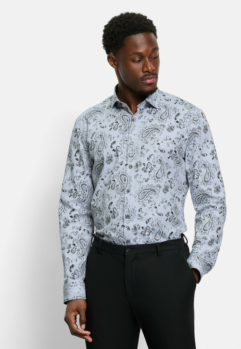 Helles blaues Langarmhemd mit einem schwarzen Paisley-Muster, klassischem Kragen und Knopfverschluss, kombiniert mit schwarzen Hosen.