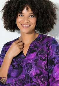 Paarse blouse met een skull- en rozenprint, v-hals ontwerp en korte mouwen. Gladde stof met een gedetailleerd, kleurrijk patroon.