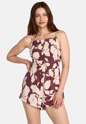 Combinaison courte bordeaux à fleurs avec bretelles spaghetti, corsage smocké et short ample. Présente de grandes fleurs crème et une texture de tissu douce.