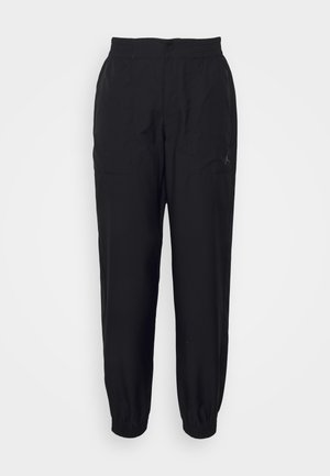 Pantaloni sportivi neri con cintura elastica, polsini affusolati e tasche laterali. Presentano un piccolo logo sulla gamba sinistra. Tessuto morbido al tatto.