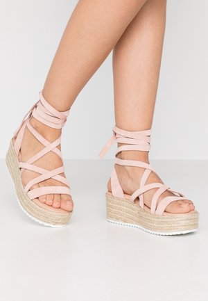 Rosa Wildleder Keilsandalen mit gekreuzten Knöchelriemen und gewebter Espadrille-Plattform. Strukturierte Innensohle und weiße Gummiaußensohle.