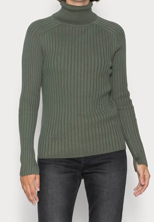 Olivgrüner, gerippter Rollkragenpullover mit langen Ärmeln, der eine figurbetonte Passform und eine subtile Textur bietet. Kombiniert mit dunklen Jeans.
