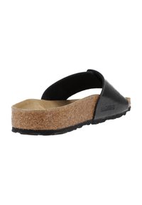 Sandalo slide in pelle nera con zeppa in sughero, suola piatta e suola in gomma; presenta un design a fascia semplice per una facile vestibilità.
