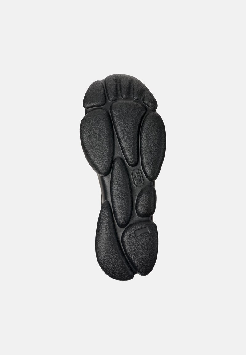 Czarna gumowa podeszwa buta z różnorodnymi, zaokrąglonymi kształtami przypominającymi pody oraz teksturowanymi powierzchniami, z wyraźnym szczegółem logo w rejonie palców.