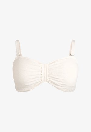 Valkoinen bandeau-tyyppinen rintaliivit, joissa on ohuet säädettävät olkaimet ja hienovarainen kuvioitu kukkakuvio kankaassa.