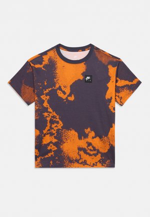 T-shirt Nike Air à manches courtes, avec un motif abstrait orange et gris anthracite foncé et un petit logo sur la poitrine, présenté sur un fond uni.