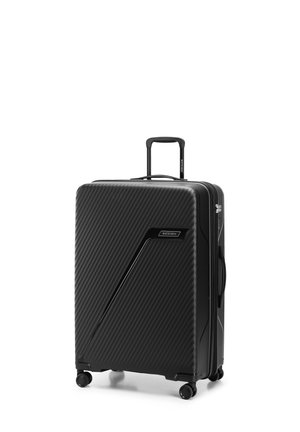 Black hardshell suitcase with a ribbed texture, integrated TSA lock, retractable handle, and four spinner wheels for easy mobility.