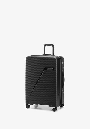 Black hardshell suitcase with a ribbed texture, integrated TSA lock, retractable handle, and four spinner wheels for easy mobility.