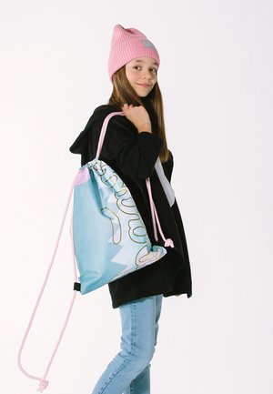 Light blue drawstring bag with yellow accents and a whimsical design, paired with a black hoodie and pink knit beanie.
