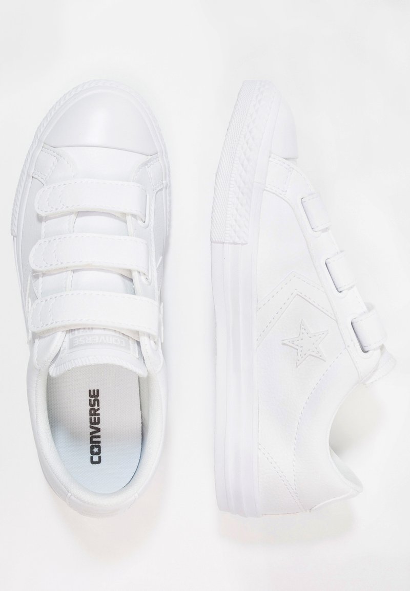 Paire de baskets blanches Converse avec des bandes velcro, logo étoile sur le côté et semelles en caoutchouc, vues de dessus et de côté.