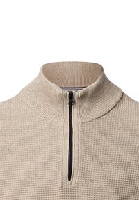 Beige Reißverschluss-Pullover mit strukturiertem Muster, geripptem Kragen und schwarzem Reißverschluss. Der Stoff wirkt weich und leicht.