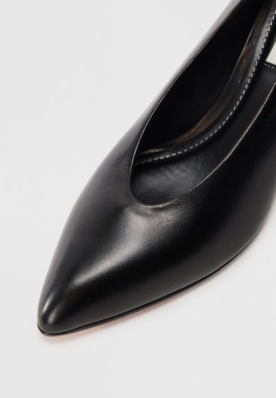 Scarpa con tacco alto in pelle nera, con punta affusolata e un design con ritagli sul lato, caratterizzata da una superficie liscia e dettagli di cucitura minimi.