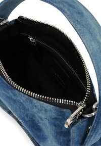 Džínová kabelka s černým interiérem, obsahující stříbrný zip, tkaninovou podšívku a robustní rukojeť. Doplňky zahrnují oranžové prošívání.