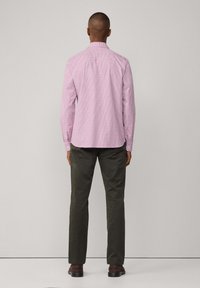 Rosa karierte Button-up-Hemd mit einer Rückenpasse, kombiniert mit olivgrünen Hosen und dunkelbraunen Schuhen, die ein Standard-Fit-Design präsentieren.