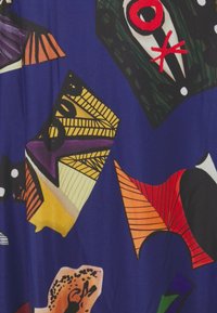 Barevná tkanina se různými abstraktními tvary a vzory na modrém pozadí. Textury zahrnují hladké a tištěné designy.