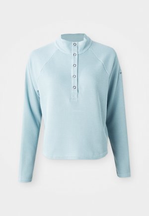 Light blue long-sleeve top with a high collar, textured fabric, and button closure. Features raglan sleeves and a cropped hem.