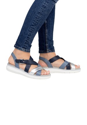 Strappy sandals with a mix of navy, light blue, and silver materials. Features adjustable buckle, white sole, and a casual design.