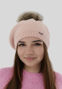 Roze gebreide baret met een grote nep bont pompon bovenop, een geribbelde band en een klein metalen accentlabel aan de zijkant.