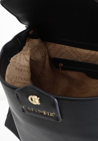 Borsa a tracolla in pelle nera con logo dorato, interno foderato in tessuto beige con nome del marchio ripetuto, include tasca con zip.