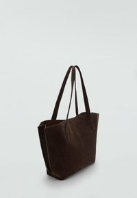 Dunkelbraune Wildleder-Tasche mit zwei langen Griffen, die ein minimalistisches Design und eine weiche Textur aufweist, mit einem breiten Öffnungsbereich an der Oberseite für einfachen Zugriff.