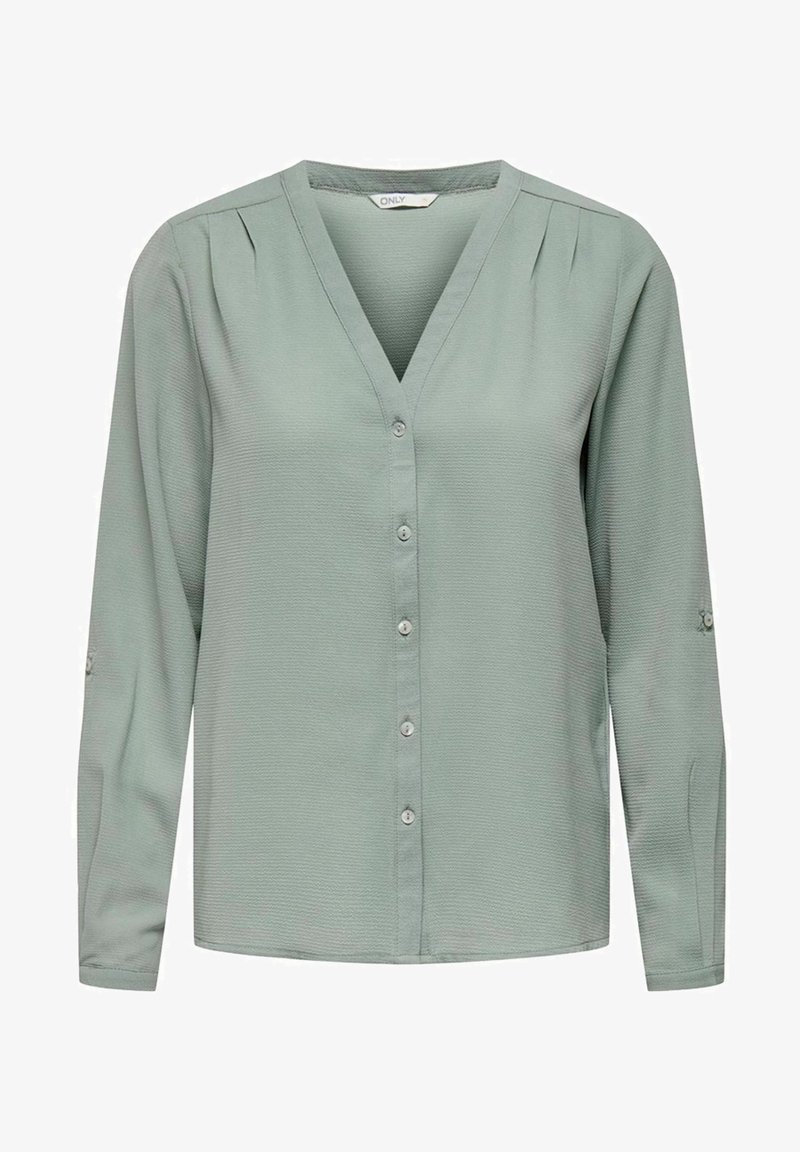 Blouse légère à manches longues pour femme, vert clair, avec col en V, boutonnée devant et plis subtils près des épaules.