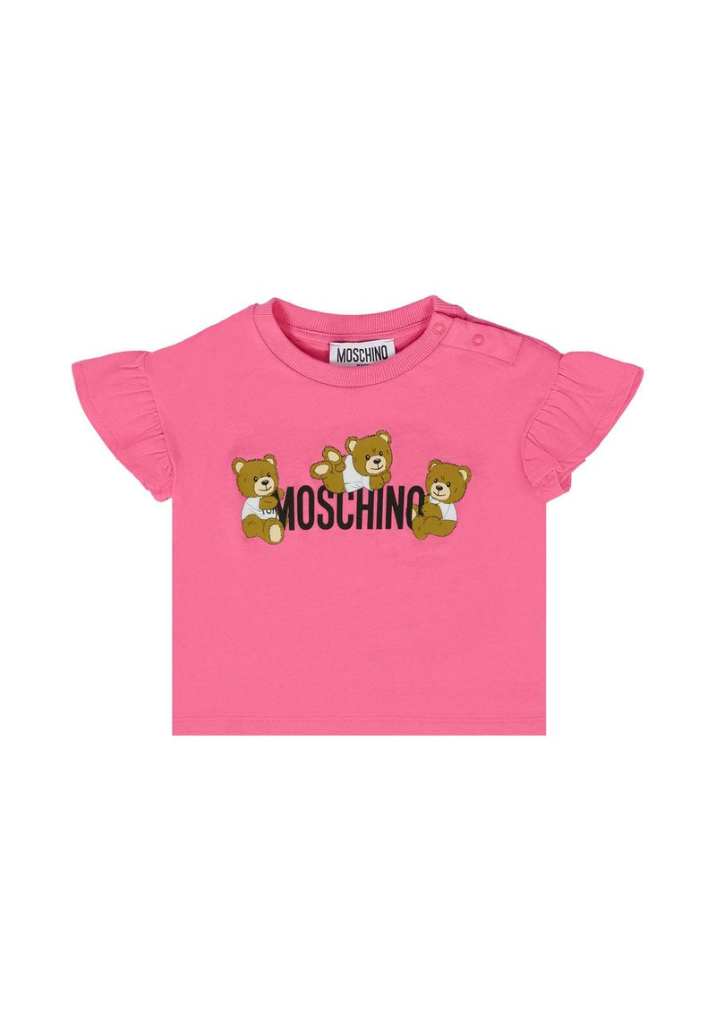 Różowa koszulka z krótkim rękawem z falbankami, z trzema rysunkowymi niedźwiedziami i napisem "Moschino" drukowanym dużymi czarnymi literami. Wykonana z bawełny.