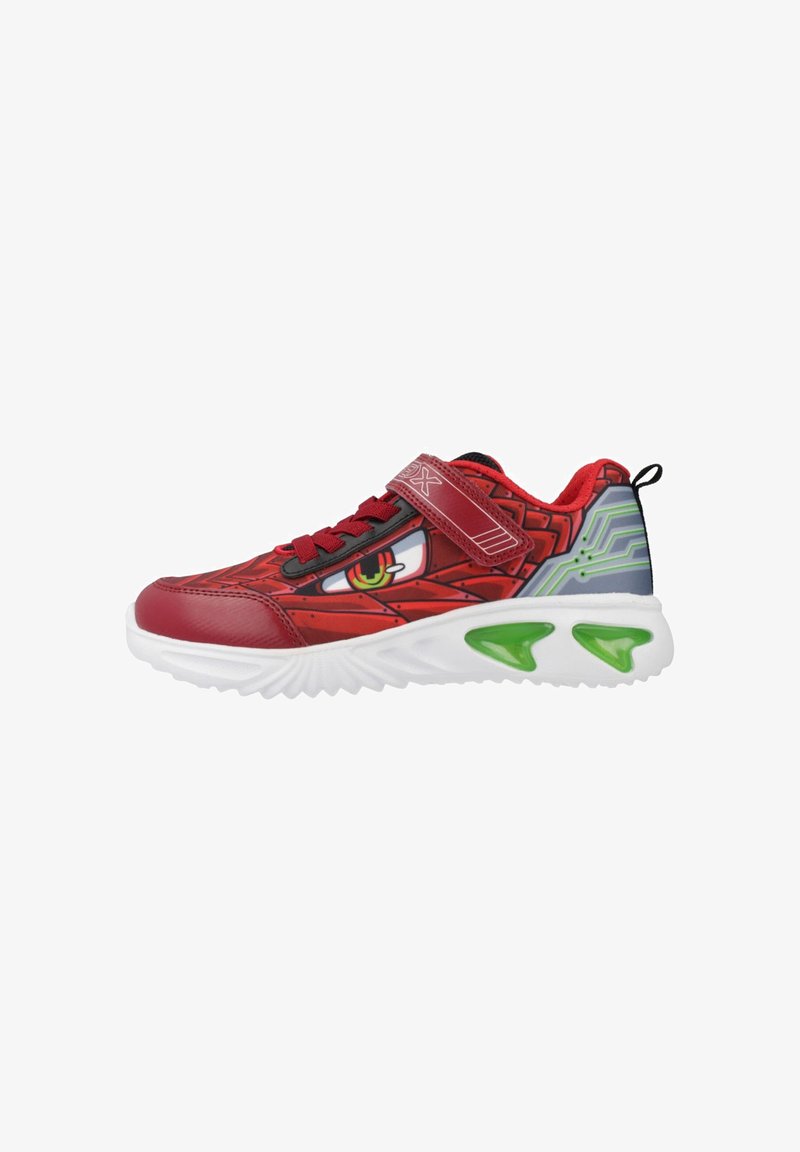 Baskets rouges avec une tige à motifs représentant un monstre, accents noirs et une sangle Velcro. Semelle blanche avec des détails verts pour une meilleure adhérence.
