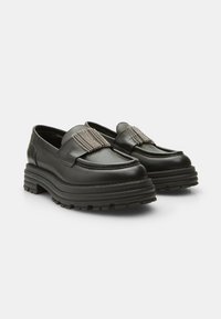Black leather loafers with a chunky sole, featuring a silver chain accent on the vamp and a smooth texture.  Distinctive treaded outsole.