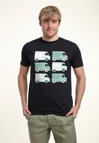 Svart t-shirt med en grafik av sex vintage-lastbilar i teal och vitt, visade i två kolumner med distinkta hjul och design detaljer.