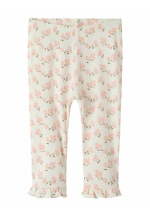 Leggings en coton à texture côtelée, présentant un motif floral rose et vert sur un fond crème clair, finis par des ourlets à volants.
