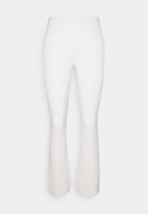 Leggings blancos de punto acanalado con cintura alta y piernas acampanadas, exhibidos sobre un fondo claro y sencillo.