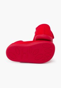 Roter Kinderschuh mit einer strukturierten Gummisohle, der eine abgerundete Ferse und gestickte Nähte aufweist. Das Innere ist weich und gepolstert.