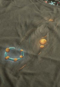 Olijfgroen t-shirt met een gestructureerde grafische print met meerkleurige cirkelvormige figuren en lijnen in turkoois, oranje en bruin.