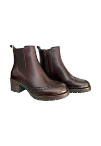 Stivaletti in pelle marrone con dettagli a brogue, pannelli laterali in elasticizzato e cerniera laterale. Tacco spesso e suola in gomma testurizzata per una migliore aderenza.