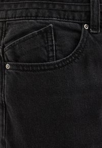 Jeans di denim neri con una finitura tessurizzata, dotati di una tasca frontale e accessori in metallo argentato sul bordo della tasca.