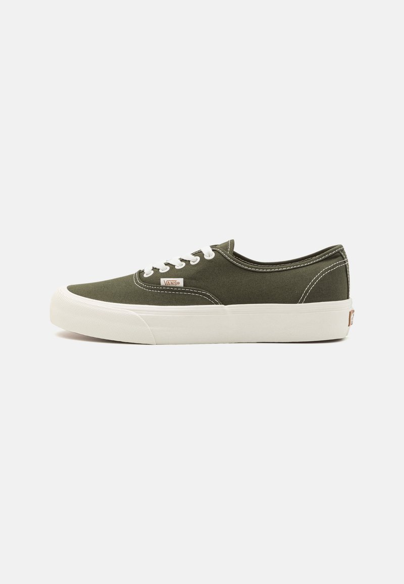 Zapatilla de lona verde oliva de caña baja de Vans con cordones blancos y suela de goma blanca gruesa, etiqueta de logo lateral y costuras en contraste.