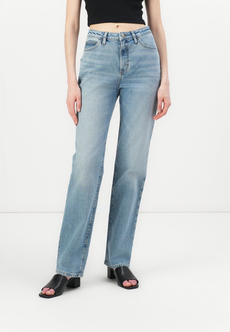 Jeans azzurri chiari a vita alta con design a gamba dritta, realizzati in denim con unaTexture liscia. Presentano una vita cucita e cinque tasche.