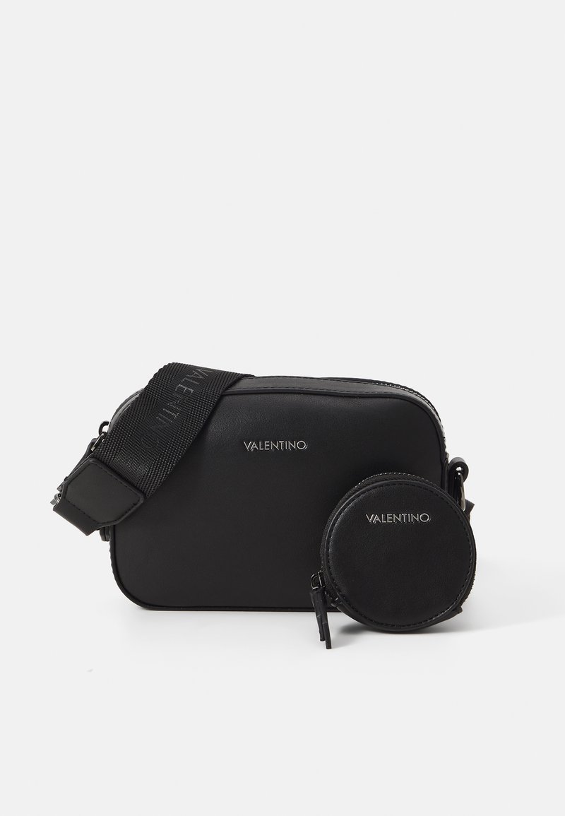 Sac en cuir noir à bandoulière de forme rectangulaire, avec du matériel argenté et une pochette circulaire détachable. Bandoulière réglable incluse.
