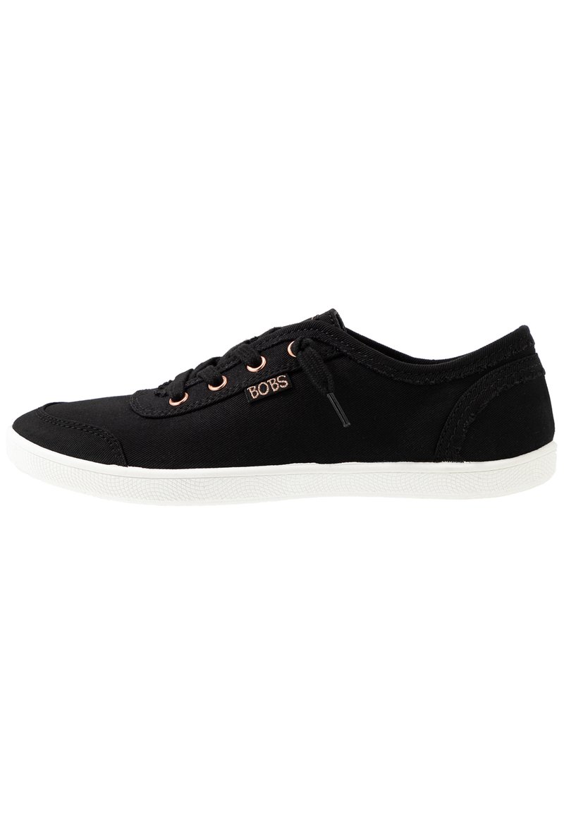 Black canvas sneaker with round toe, white rubber sole, rose gold eyelets, and logo detailing on the side. Textured fabric for grip.