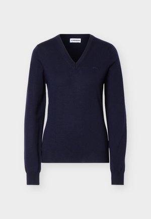 Tamsiai mėlynas ilgomis rankovėmis V formos kaklo megztinis su briaunotais rankogaliais ir apačia, krūtinėje yra maža išsiuvinėta logotipo detalė.