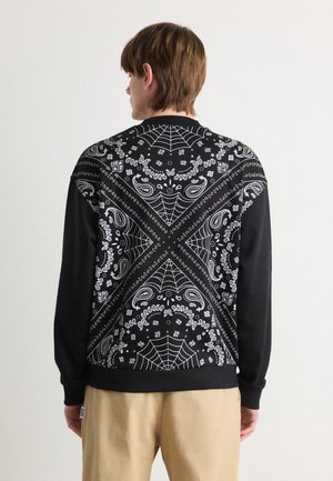 Felpa nera con motivo bandana caratterizzato da paisley bianchi e ragnatele. Maniche lunghe e vestibilità comoda.