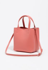 Bolso de mano de cuero rosa con un diseño estructurado, dos asas cortas y una correa de hombro desmontable. Presenta costuras mínimas y sin bolsillos exteriores.