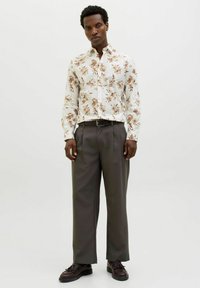 Witte lange mouw shirt met bloemenmotieven in bruintinten, gecombineerd met grijze wijde broek en donkerbruine schoenen. Eenvoudig ontwerp, gladde textuur.